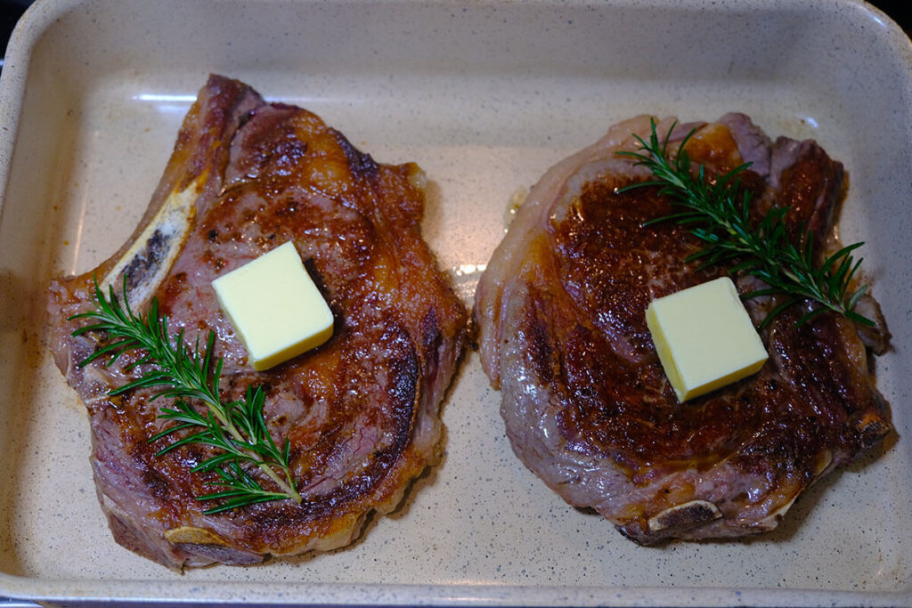 medium-rare steak with butter and rosemary